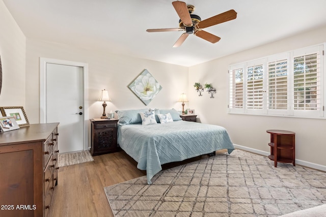 bedroom with a ceiling fan, light wood-type flooring, and baseboards