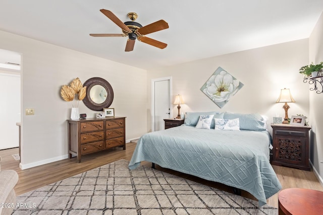 bedroom with a ceiling fan, light wood-type flooring, and baseboards