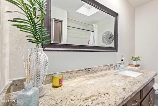 bathroom with a skylight, toilet, vanity, and a shower with shower curtain