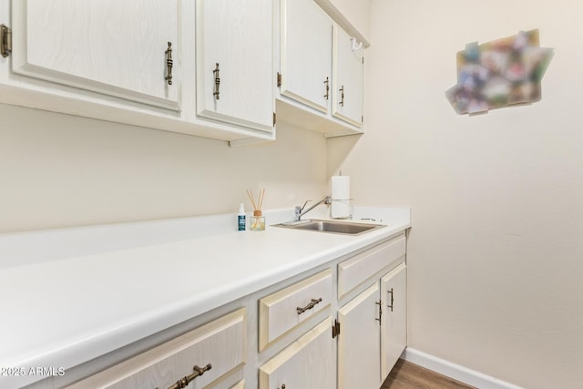 interior space featuring dark wood-style floors, baseboards, and a sink