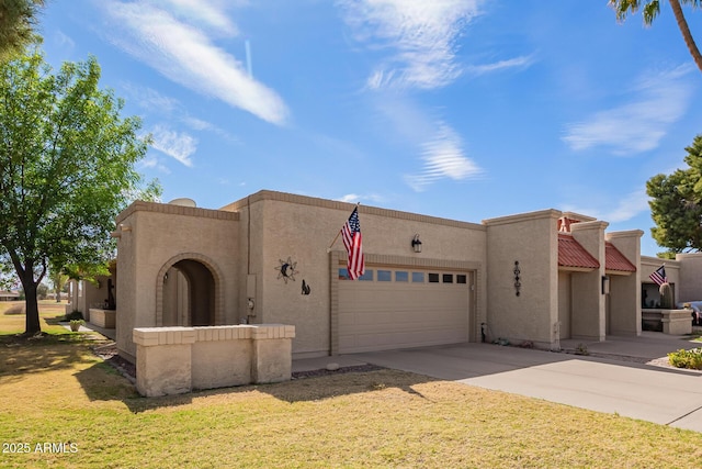 view of front of home featuring a front yard, driveway, an attached garage, and stucco siding