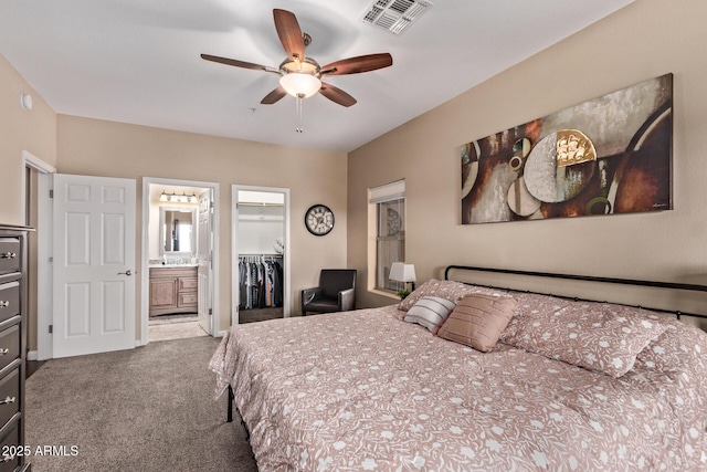 bedroom with visible vents, a walk in closet, connected bathroom, a closet, and carpet flooring