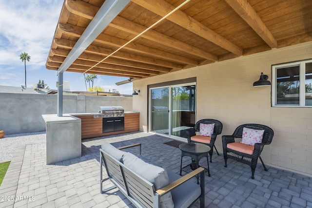 view of patio with outdoor lounge area, fence, and area for grilling