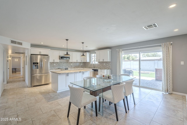 dining area with visible vents, a healthy amount of sunlight, and baseboards