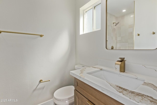 full bath with a tile shower, toilet, and vanity