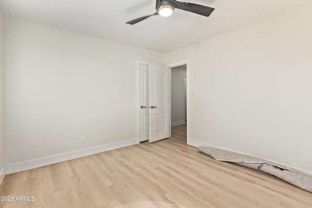 empty room with light wood-style floors, baseboards, and ceiling fan