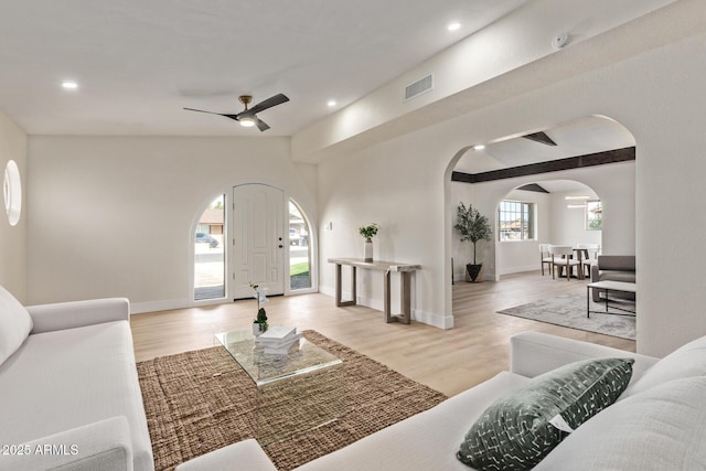 living room with recessed lighting, visible vents, arched walkways, and wood finished floors