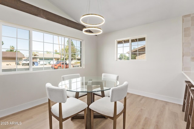 dining space with baseboards, plenty of natural light, lofted ceiling, and light wood-style flooring