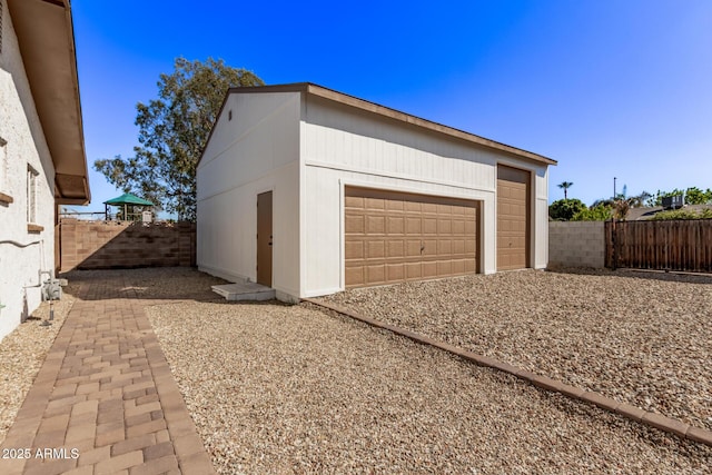 detached garage featuring fence