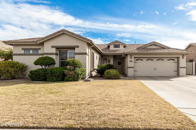 ranch-style home featuring a tile roof, stucco siding, concrete driveway, a front yard, and a garage