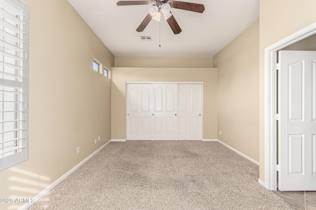 unfurnished bedroom featuring baseboards, visible vents, a ceiling fan, carpet floors, and a closet