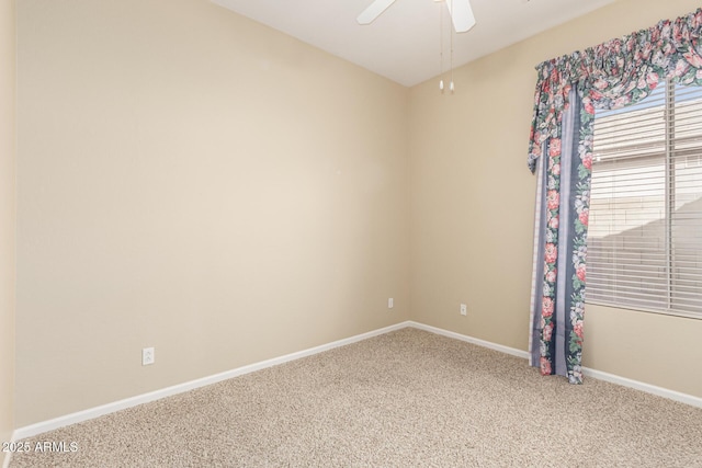 spare room featuring carpet, baseboards, and a ceiling fan