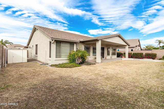 back of property featuring a patio, a fenced backyard, a tile roof, a yard, and stucco siding