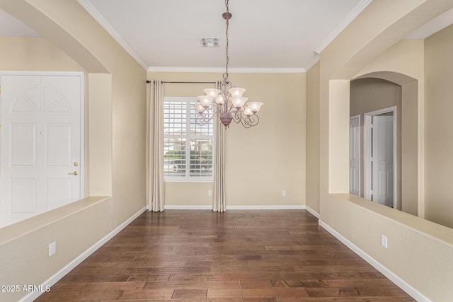 unfurnished dining area with dark wood-style floors, arched walkways, crown molding, visible vents, and baseboards