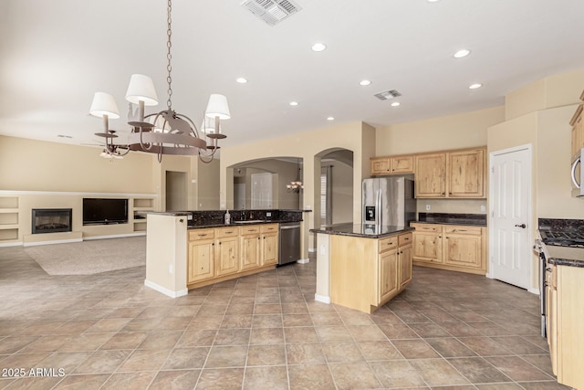 kitchen with stainless steel appliances, light brown cabinets, visible vents, and a center island