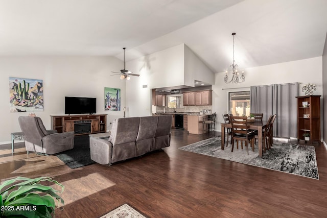 living room with high vaulted ceiling, dark hardwood / wood-style flooring, and ceiling fan with notable chandelier