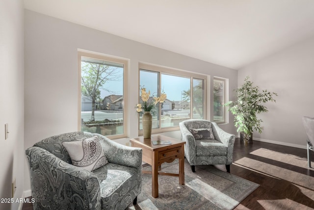 living area with hardwood / wood-style floors and a water view