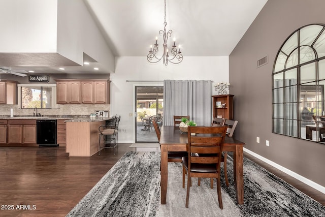 dining room with an inviting chandelier, sink, high vaulted ceiling, and dark hardwood / wood-style floors