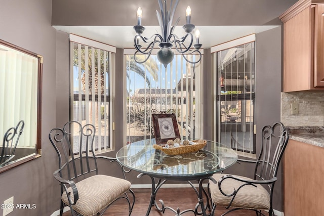 dining space with hardwood / wood-style floors and a notable chandelier