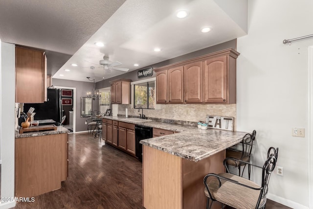 kitchen with black appliances, sink, backsplash, a kitchen bar, and kitchen peninsula