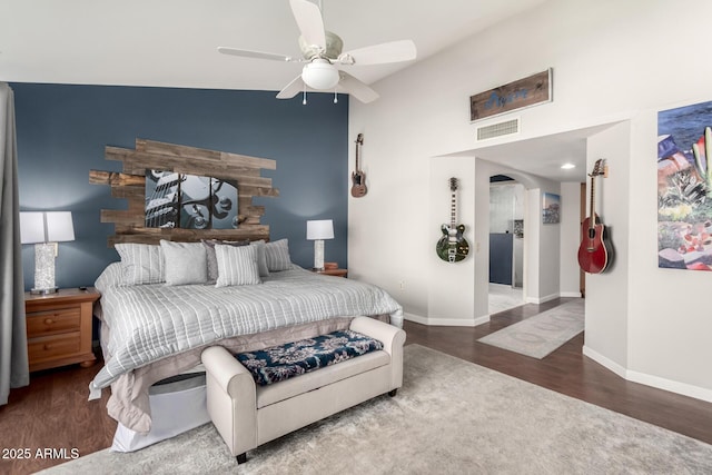 bedroom featuring ceiling fan, hardwood / wood-style floors, and a towering ceiling