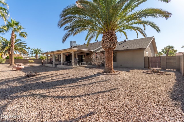 rear view of house with central AC unit and a patio area