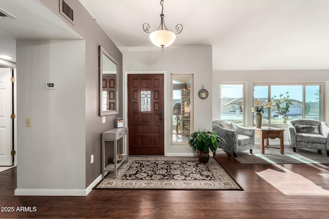 entryway with vaulted ceiling and dark hardwood / wood-style flooring