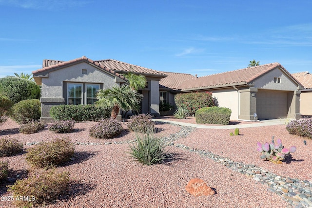 view of front of home featuring stucco siding, an attached garage, and a tiled roof