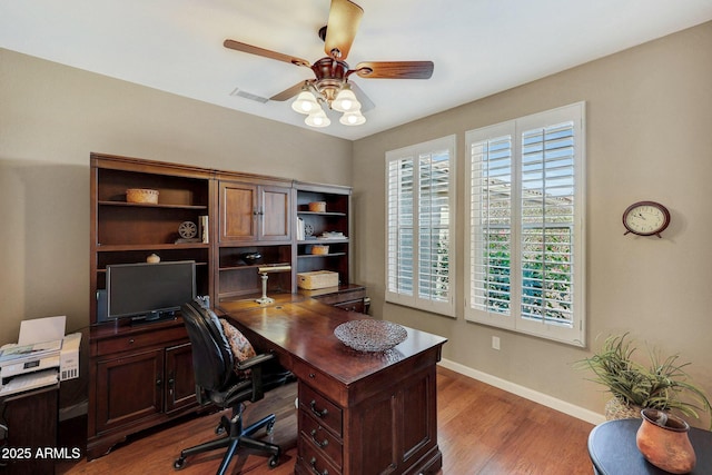 home office featuring dark hardwood / wood-style floors and ceiling fan