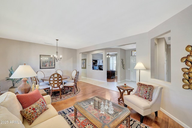 living room featuring hardwood / wood-style flooring and ceiling fan with notable chandelier