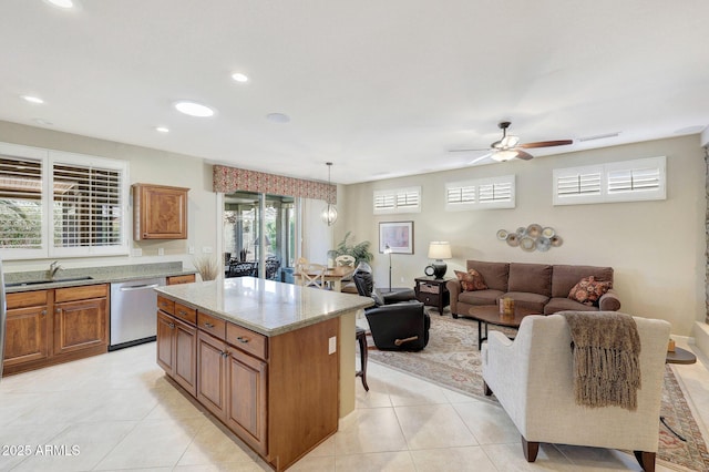 kitchen with stainless steel dishwasher, a center island, hanging light fixtures, and light tile patterned floors