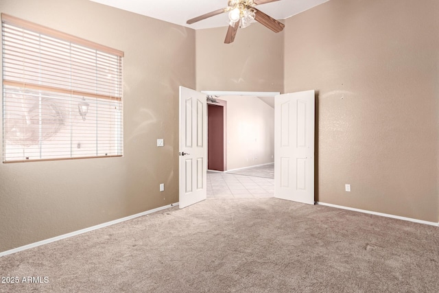 carpeted spare room with ceiling fan