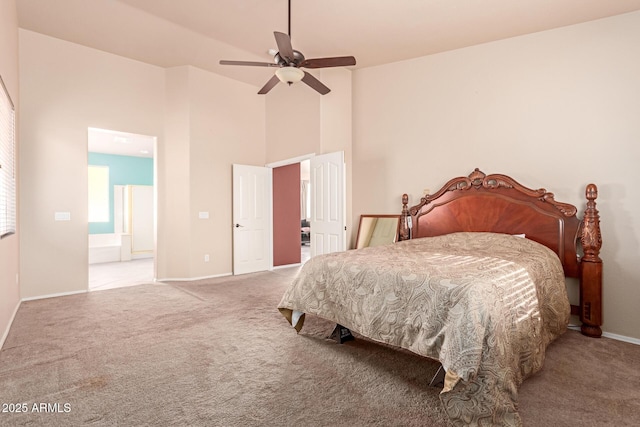 carpeted bedroom with ceiling fan, ensuite bathroom, and a towering ceiling