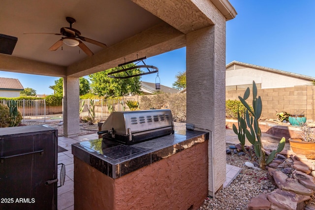 view of patio with ceiling fan, an outdoor kitchen, and area for grilling