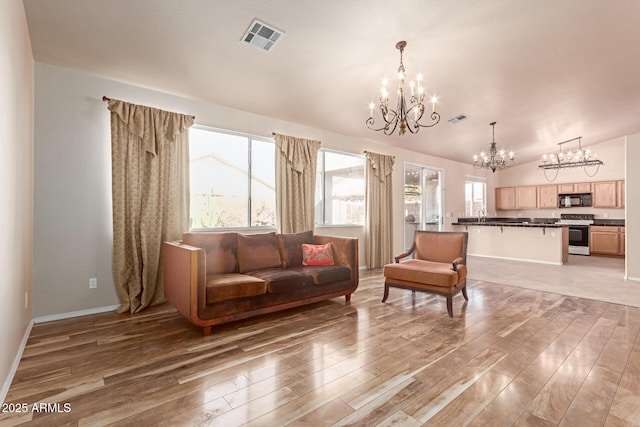 living room featuring wood-type flooring, a chandelier, and lofted ceiling