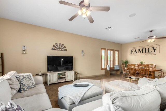 living room with ceiling fan with notable chandelier