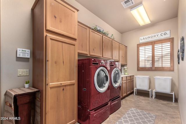 washroom featuring washer and clothes dryer, cabinets, and light tile patterned floors