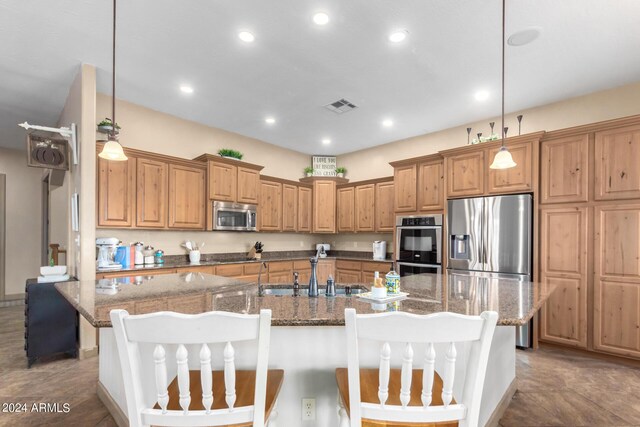 kitchen featuring hanging light fixtures, an island with sink, stainless steel appliances, sink, and a notable chandelier