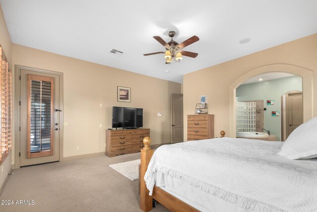 carpeted bedroom featuring multiple windows, connected bathroom, and ceiling fan