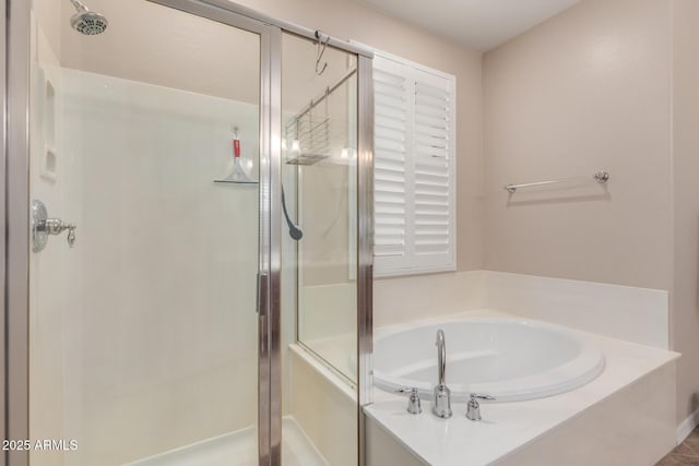 full bathroom featuring a shower stall and a garden tub