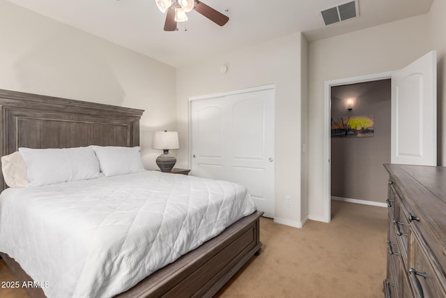 bedroom with light colored carpet, baseboards, a closet, and ceiling fan