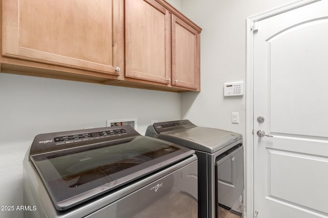 washroom featuring separate washer and dryer and cabinet space