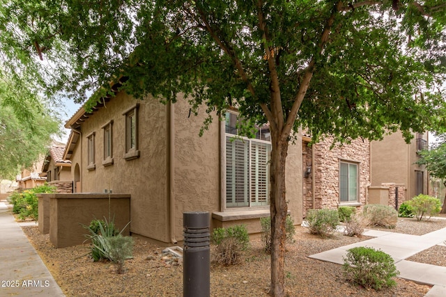 view of side of property featuring stucco siding and fence