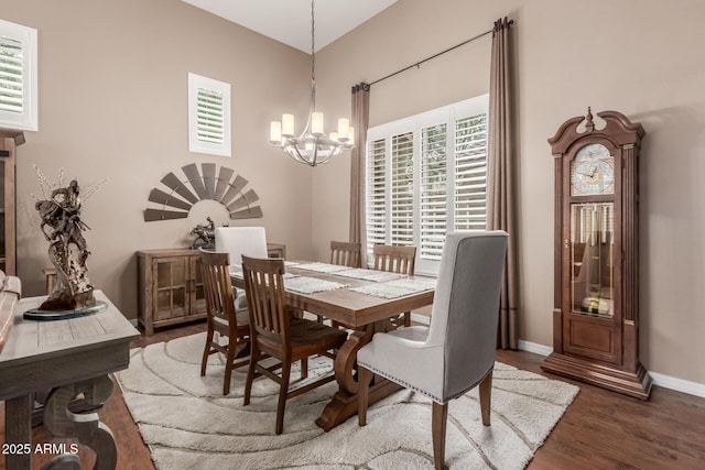 dining area featuring a chandelier, wood finished floors, and baseboards