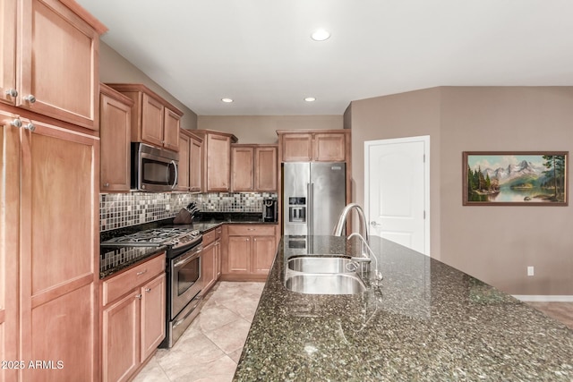 kitchen with stainless steel appliances, a sink, backsplash, dark stone counters, and recessed lighting