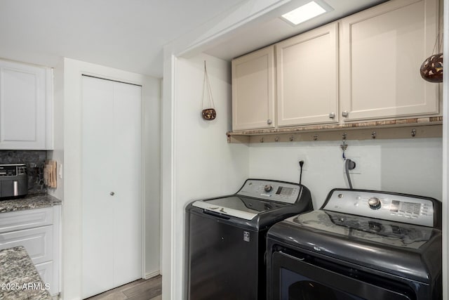 laundry room with cabinet space, separate washer and dryer, and wood finished floors