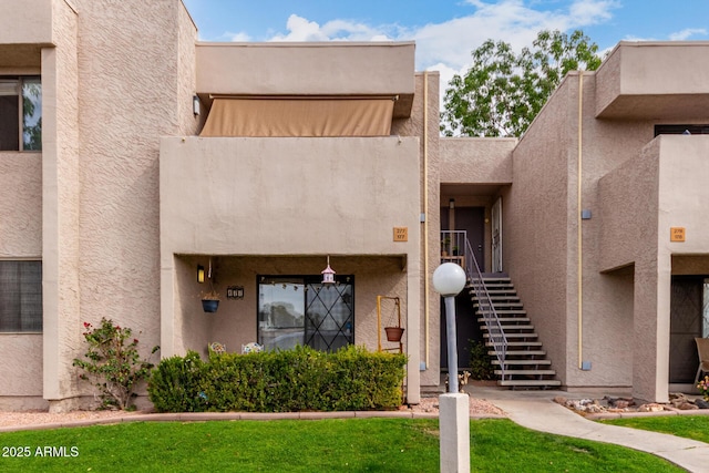 exterior space with a lawn and stucco siding