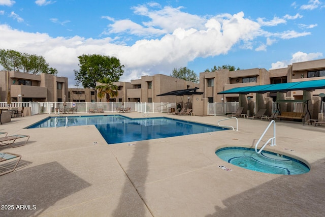 pool featuring a patio area, a residential view, fence, and a community hot tub