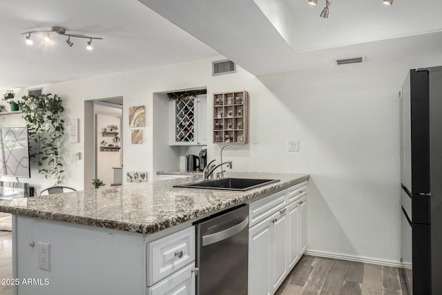 kitchen featuring stone counters, stainless steel appliances, visible vents, white cabinetry, and light wood-type flooring