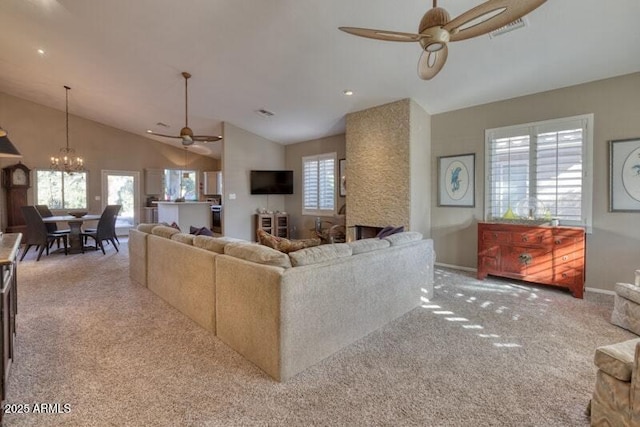 living room with ceiling fan with notable chandelier, light colored carpet, and lofted ceiling